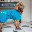 Cockapoo wearing a personalised teal Original dog towel coat embroidered with Hazel