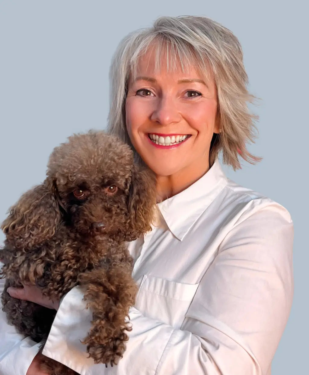 Margaret, owner of Dogrobes with her chocolate Toy Poodle Coco