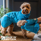 Person using Teal Dogrobes Dog Drying Gauntlets (mitts) to dry a wet Cockapoo's paws while dog wearing Teal Dogrobe and Snood