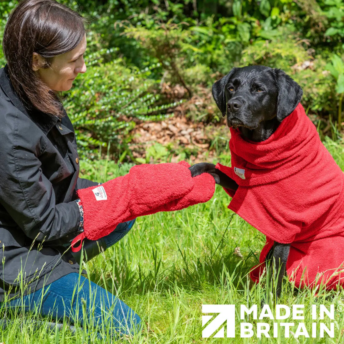 Woman using Red Dogrobes Dog Drying Gauntlets to dry a wet Labrador’s paws while dog wearing red Dogrobe and Snood