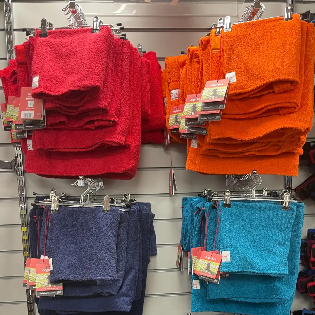 Colour-blocked display of Original Dogrobes dog drying coats in red, orange, navy and teal