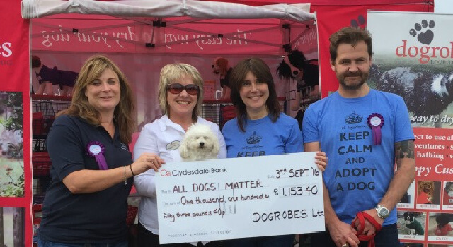 Margaret from Dogrobes presents a cheque for £1,153.40 to Ira Moss and friends from the charity All Dogs Matter.