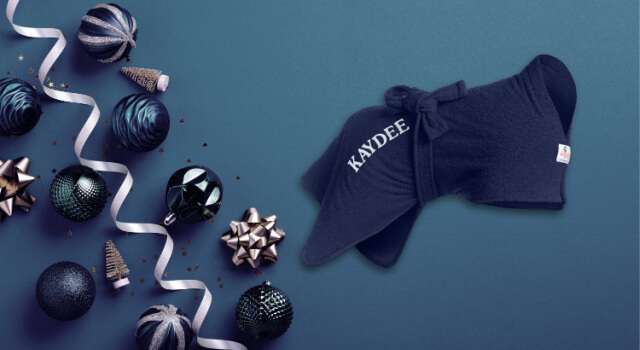 Navy Dogrobe personalised with the name Kaydee embroidered on the hip, on a blue background with Christmas baubles