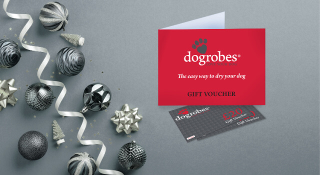 Dogrobes Gift Vouchers presented in a branded card, on a silver background with Christmas baubles