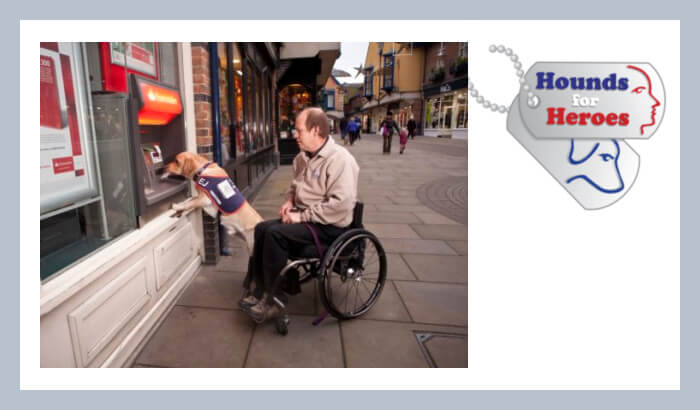 Hounds for Heroes founder, Allen Parton in his wheelchair with assistance dog EJ taking money out of the cash machine.